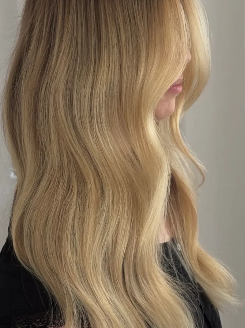 Biondo dorato su capelli lunghi e mossi, visti di lato