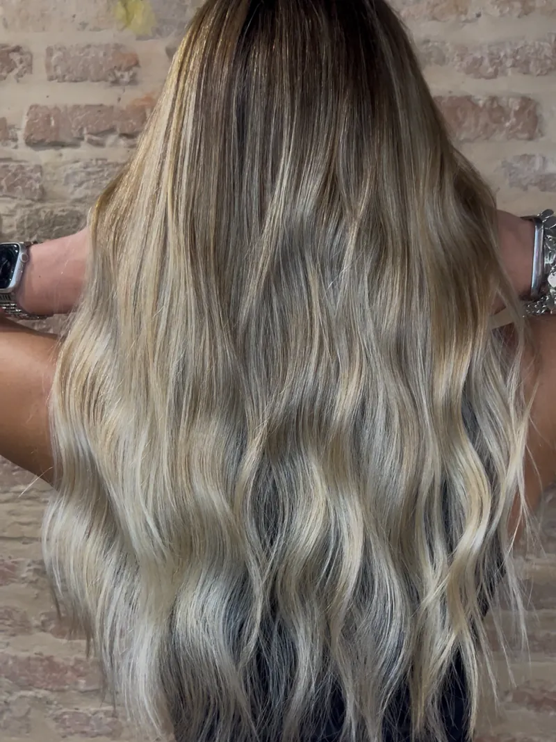 Biondo freddo tendente al grigio su capelli lunghi e mossi, visti da dietro